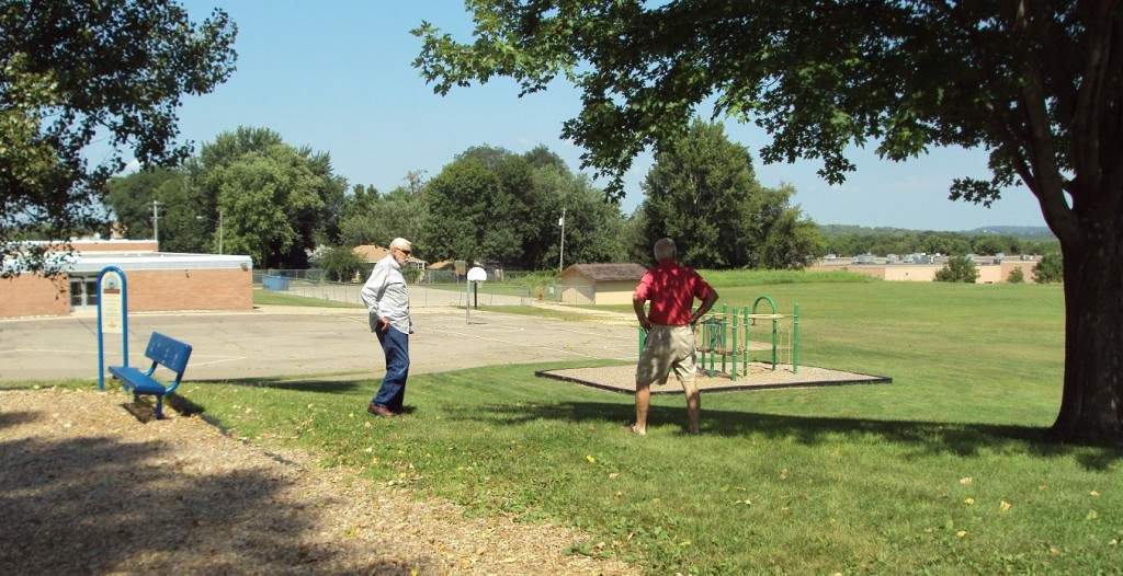 George Nelson, left, and Bill McNamara stand near the site of the tee box on the old second hole at Valley View/Hastings GC/Hastings CC. In the background are the Mississippi River bluffs on the Wisconsin side.